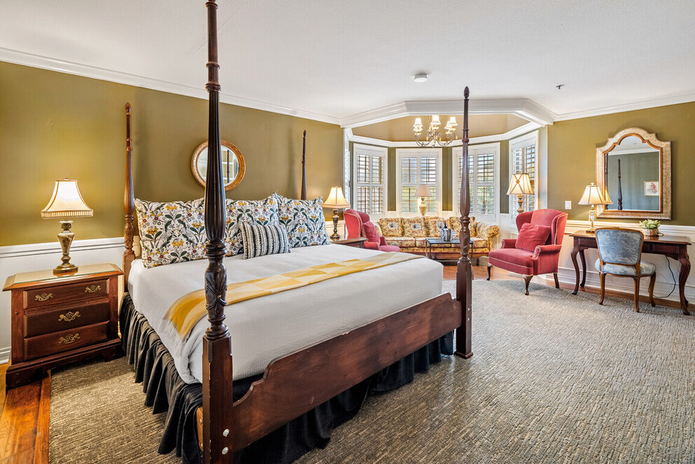 a room with a four poster bed and a couch